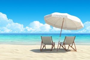 Chaise lounge and umbrella on sand beach.